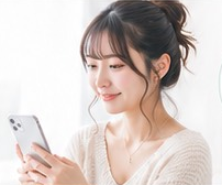 一人でスマートフォンを操作する女性のイメージ